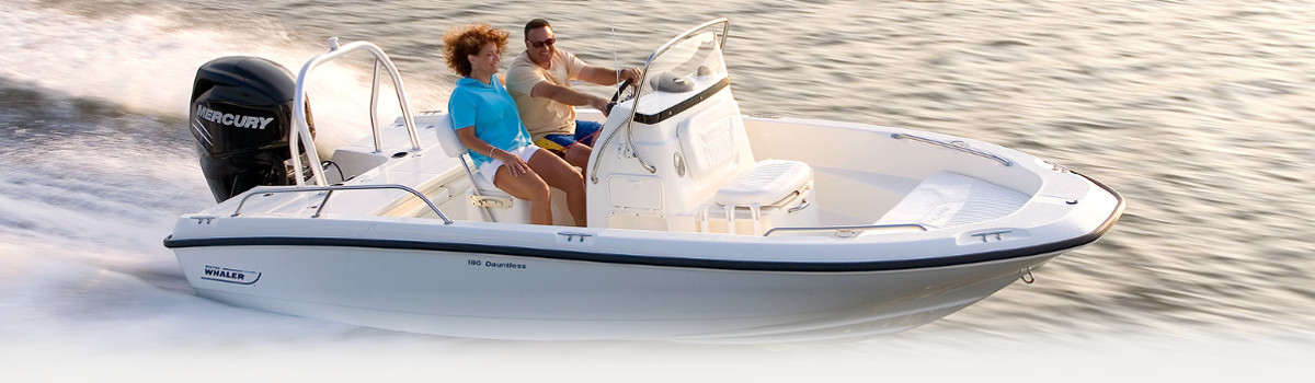 A couple speeding a white 2017 Boston Whaler 180 Dauntless through the water